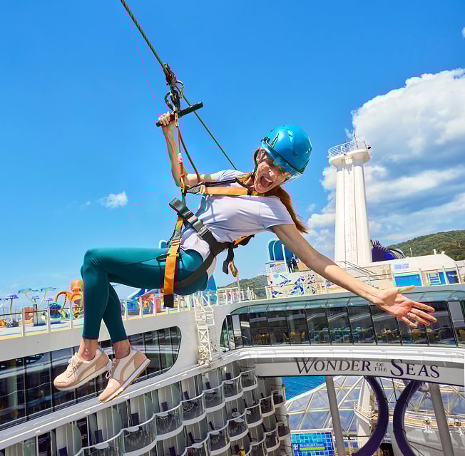 A woman rappels off of the ship, through the air